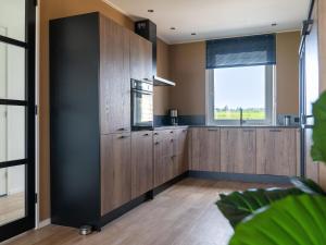 eine Küche mit Holzschränken und einem Fenster in der Unterkunft 20-person group home in the heart of Friesland in Leons