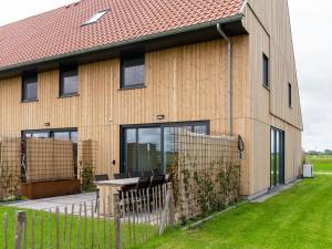 ein Holzgebäude mit einem Tisch und einem Zaun in der Unterkunft 20-person group home in the heart of Friesland in Leons