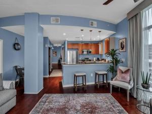 una sala de estar con paredes azules y una cocina con sillas. en 2/2 PENTHOUSE DOWNTOWN with large Billiard room, en Orlando
