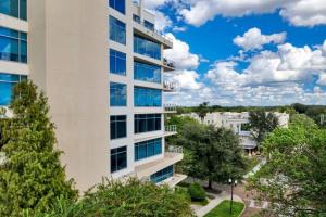 un edificio de apartamentos con árboles en el primer plano en 2/2 PENTHOUSE DOWNTOWN with large Billiard room, en Orlando