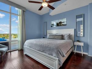 a blue bedroom with a bed and a ceiling fan at 2/2 PENTHOUSE DOWNTOWN with large Billiard room in Orlando