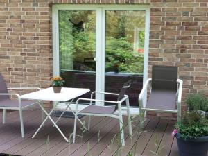 un patio con mesa y sillas en un porche en Apartment bare with ebike rental, en Oldenburg
