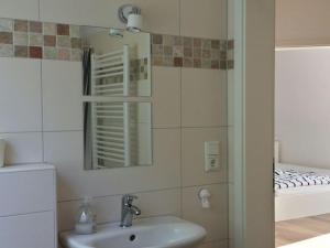 Apartment bare with ebike rental في أولدنبورغ: حمام مع حوض ومرآة