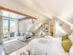 a bedroom with a large white bed and a chair at Hillcrest Cottage in Stroud