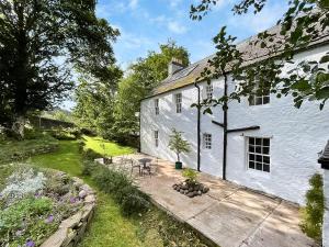 ein weißes Haus mit einer Terrasse und einem Garten in der Unterkunft Applecross Manse in Applecross