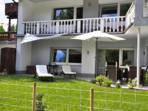 a house with a patio with an umbrella and chairs at Lovely apartment near centre in Holzminden