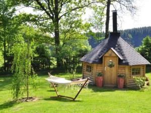 a small cabin with a table and a chair in the grass at Lovely apartment near centre in Holzminden