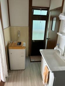 a small bathroom with a sink and a door at 高知県　みどりの家 in Gomen