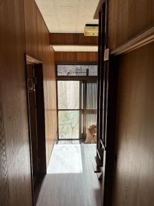 an empty hallway with a door and a window at 高知県　みどりの家 in Gomen