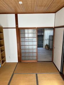 an empty room with a door and a room with a television at 高知県　みどりの家 in Gomen