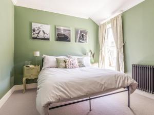 Dormitorio verde con cama y ventana en Hereward House en Margate