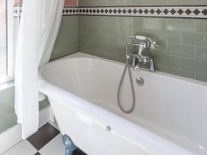 y baño con bañera blanca y ducha. en Hereward House en Margate