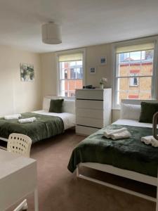 a bedroom with two beds and a dresser at Lovely Private Rooms in Camden, Central London in London