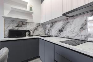 a kitchen with a sink and a microwave at Стильные апартаменты in Astana