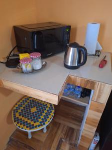 eine Küchentheke mit Mikrowelle und einem Tisch in der Unterkunft Valsalms in Chaguanas Village + 5 Fotos