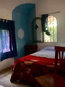 a bedroom with a bed and a window and a mirror at Sonqo Wasi in Cruz del Eje