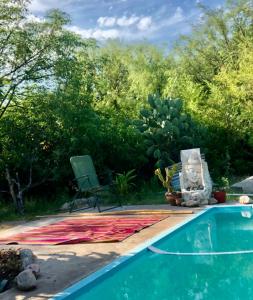 a blanket next to a swimming pool with aitating at Sonqo Wasi in Cruz del Eje