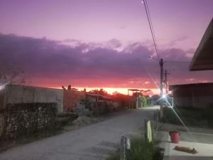 una calle vacía con una puesta de sol en el fondo en Las kaicas, en Acacías