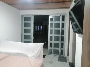 Habitación con cama, TV y espejo. en Las kaicas, en Acacías