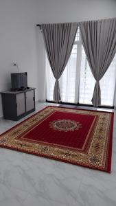 a room with a rug in front of a window at Homestay Rumi in Machang
