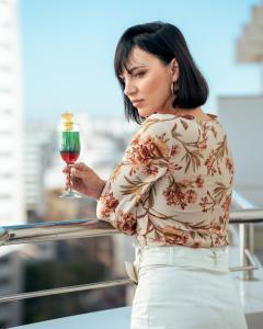 une femme tenant un verre de vin rouge dans l'établissement Oum Palace Hotel & Spa, à Casablanca