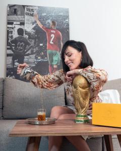 una mujer sentada en un sofá con una mesa con un trofeo en Oum Palace Hotel & Spa, en Casablanca