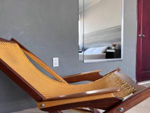 a wooden rocking chair in a bedroom with a mirror at Depa doble centrico con Restaurante Terraza in Orizaba