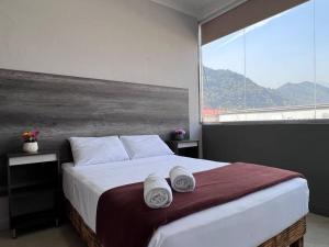 a bedroom with a large bed with towels on it at Depa doble centrico con Restaurante Terraza in Orizaba