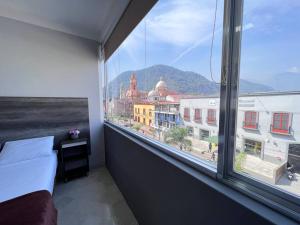 a bedroom with a large window with a view of a city at Depa doble centrico con Restaurante Terraza in Orizaba +36 photos