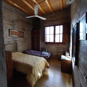 1 dormitorio con 1 cama y ventilador de techo en Las Violetas en 