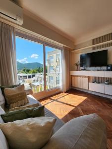 a living room with a large window and a television at Paseo Balcarce Suite in Salta