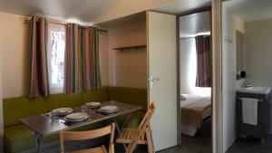 Cette petite chambre comprend une table et un lit. dans l'établissement Camping Principina, à Principina a Mare