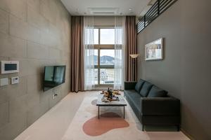 a living room with a couch and a table at Ocean Terrace Yeosu in Yeosu