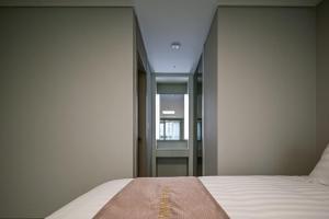 sypialnia z łóżkiem i lustrem w obiekcie Ocean Terrace Yeosu w mieście Yeosu