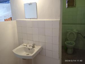 La salle de bains est pourvue d'un lavabo et de toilettes. dans l'établissement Campement Kunja, à Kafountine