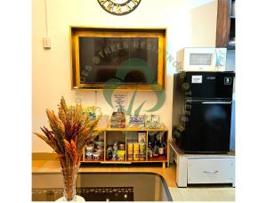 een keuken met een aanrecht met een magnetron en een wastafel bij Simply COZY at Trees Residences - Studio Balcony in Manilla