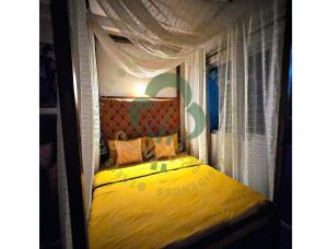een slaapkamer met een geel bed en een baldakijn bij Simply COZY at Trees Residences - Studio Balcony in Manilla