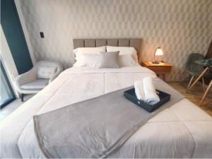 een slaapkamer met een groot bed en een stoel bij BeKAWS: Suite in Quito