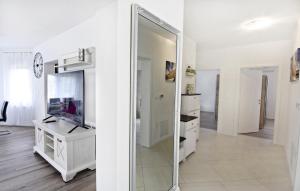 a mirror in a white room with a tv and a desk at Family friendly house with a swimming pool Buroli, Umag - 22400 in Umag