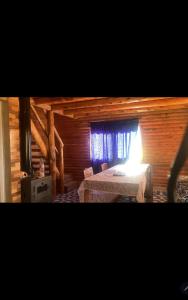 um quarto com uma cama num chalé de madeira em Cabañas doña vivi em Valle Hermoso
