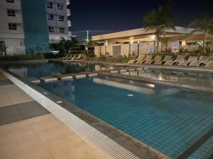 a swimming pool with chairs and a building at Minimalist Condo Studio at Messavire Garden Residence near Ruins Bacolod in Bacolod +4 photos