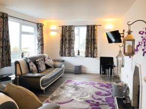 a living room with a couch and a tv at Ballygroggan Bungalow - Uk38174 in Machrihanish