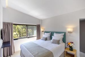 a bedroom with a large bed and a large window at Villa Lagoon in Vourvourou