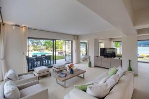 un soggiorno con divani bianchi e TV di Villa Lagoon a Vourvourou