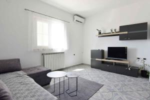 a living room with a couch and a tv at Apartments with a parking space Valica, Umag - 22453 in Umag