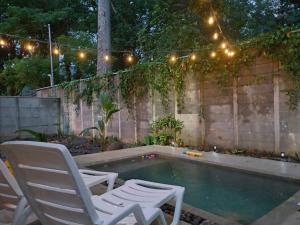 two chairs and a pool with lights and a fence at Uvita Stone House in Uvita