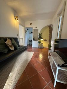 uma sala de estar com um sofá preto e piso em azulejo em Be My Guest Perugia em Perugia