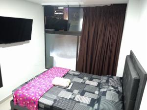 sypialnia z łóżkiem i telewizorem z płaskim ekranem w obiekcie Apartamento amoblado Medellin w mieście Medellín