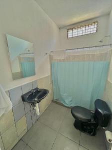 uma casa de banho com um WC preto e um lavatório. em Hotel Citadin zona 5 em Guatemala