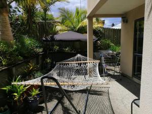 een hangmat op een patio met een tafel en een parasol bij Sunny Sandringham SkyTower Views Close to City in Auckland